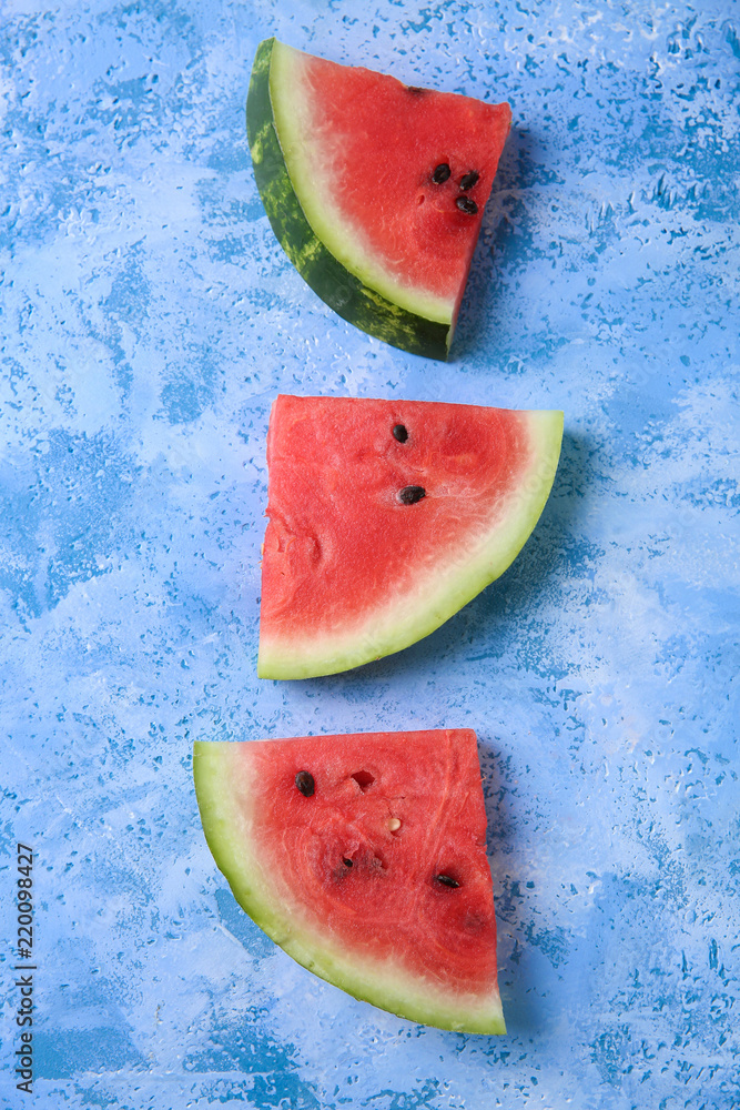 Slices of ripe watermelon on color background