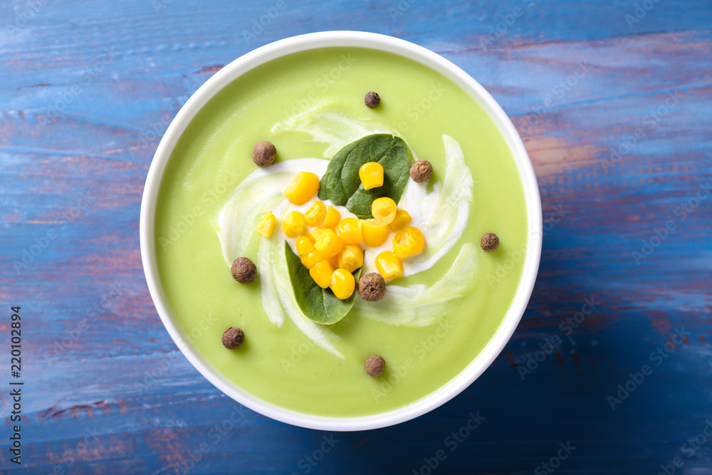 Bowl with delicious zucchini soup on color table