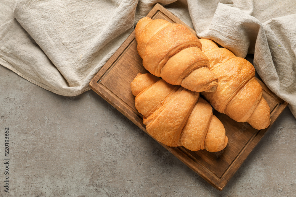 Tasty croissants on wooden board