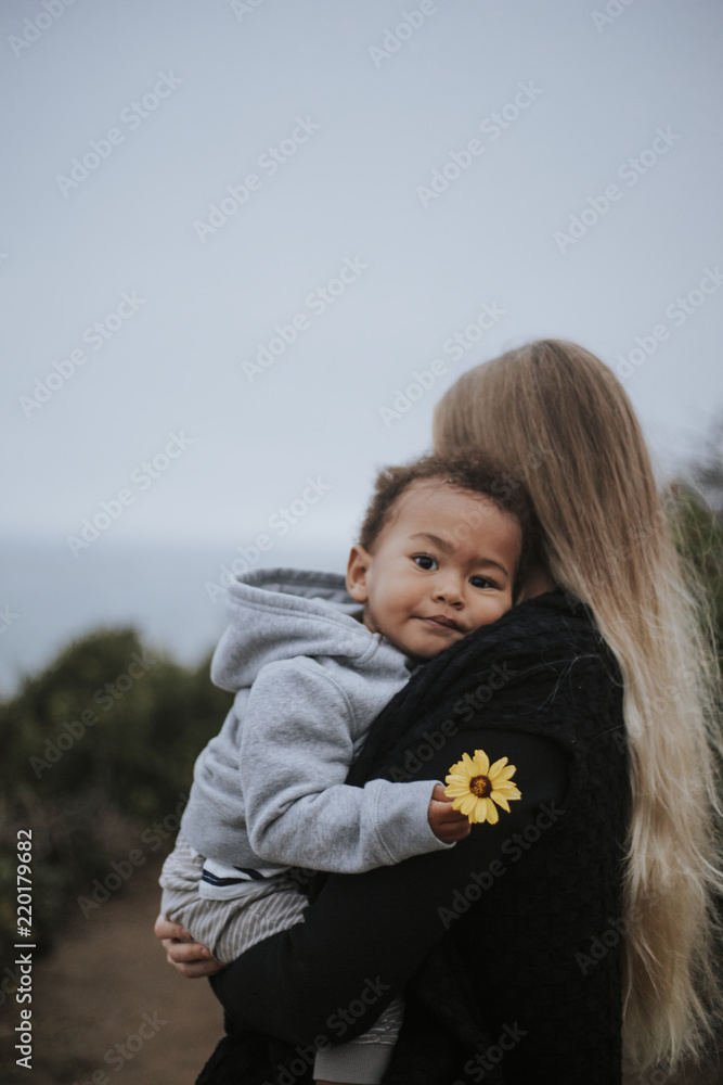 小男孩手里拿着妈妈提的花