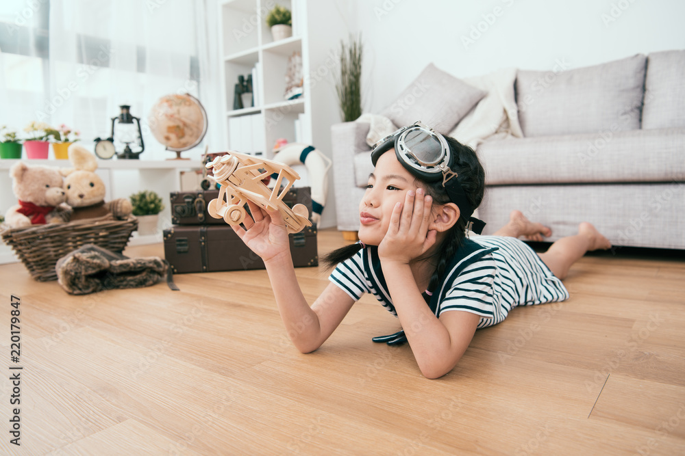 kid lying on her belly and playing with her toy.