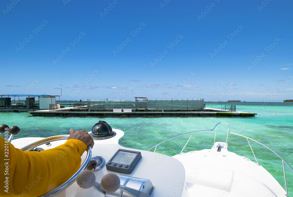 Hand of captain on steering wheel of motor boat in the blue ocean during the fishery day. Success fi