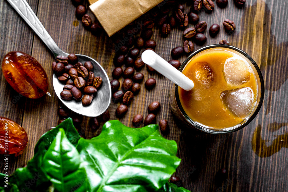 coffee with ice in glass on wooden background top view