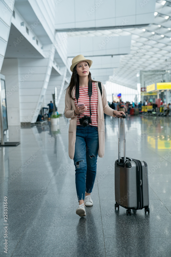 visitor walking while carrying her luggage.