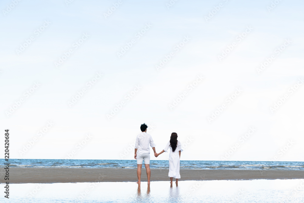 Couple going honeymoon on tropical beach in summer