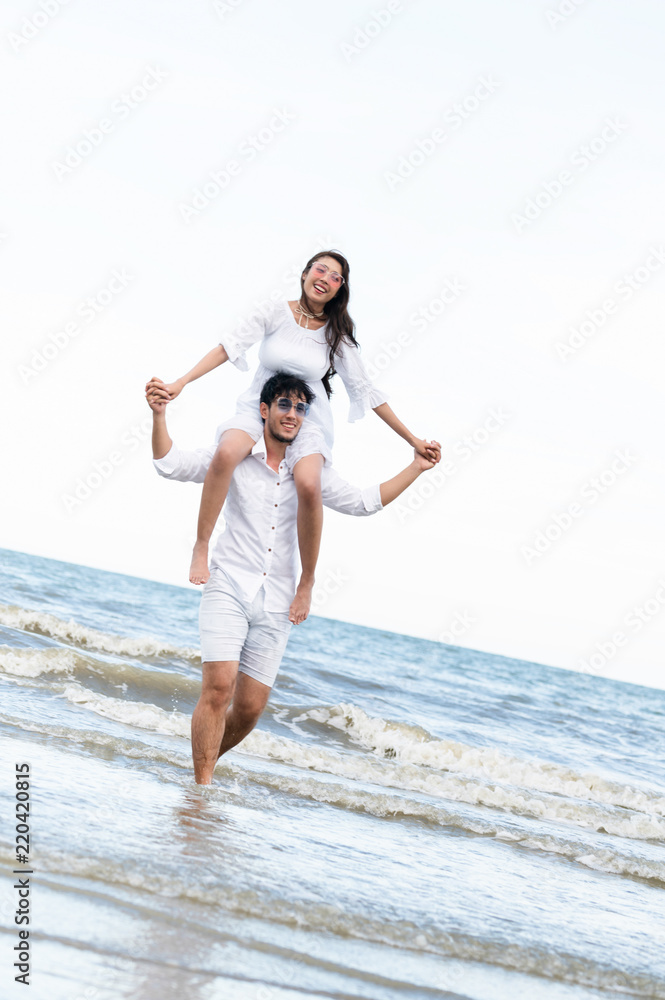 Couple going honeymoon on tropical beach in summer