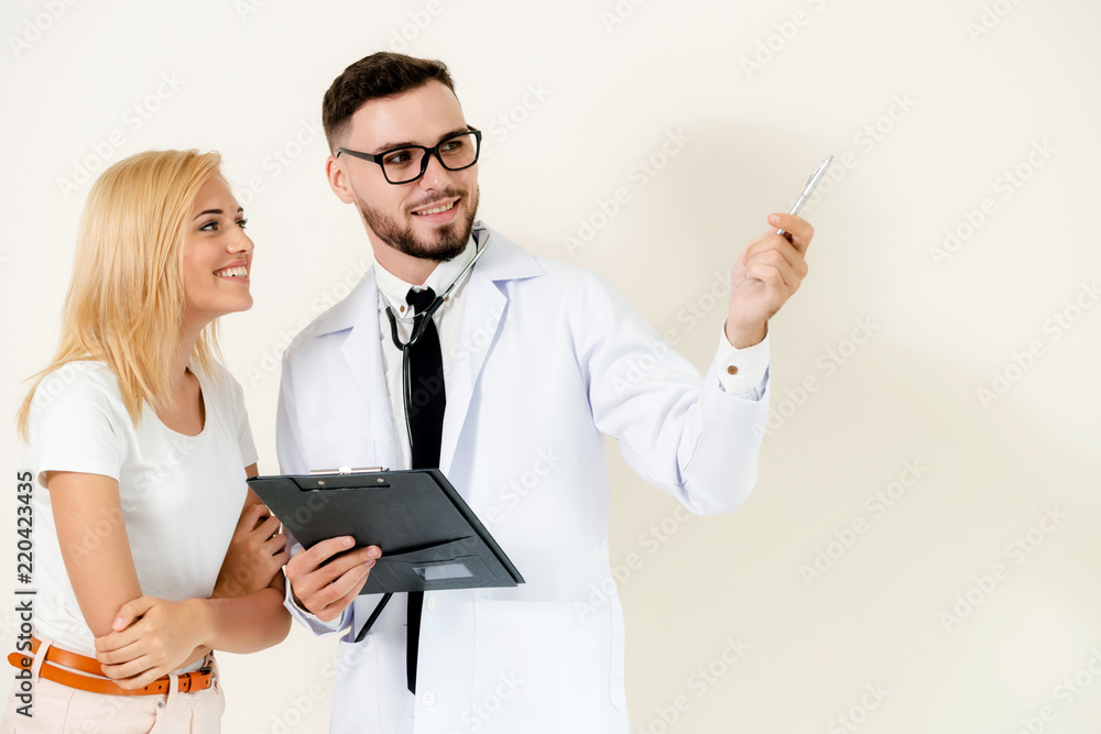 Male doctor with patient points pen at copy space.