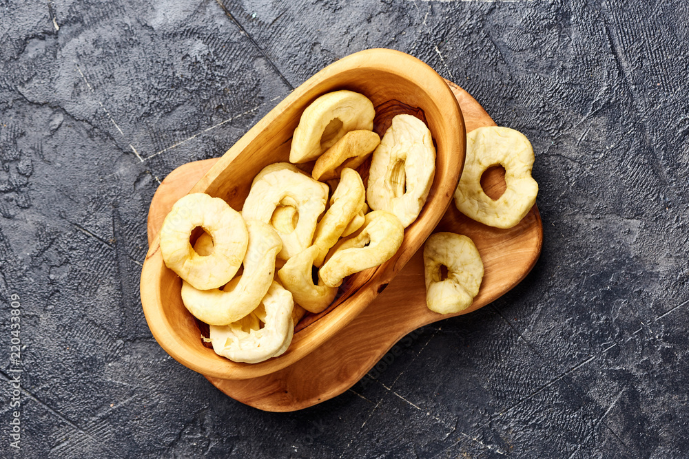 Dried apple rings on black background. Top view.