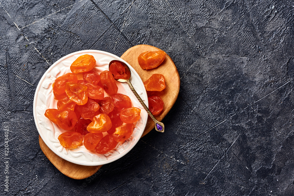 Dried orange kumquat on black background. Top view of fruits.