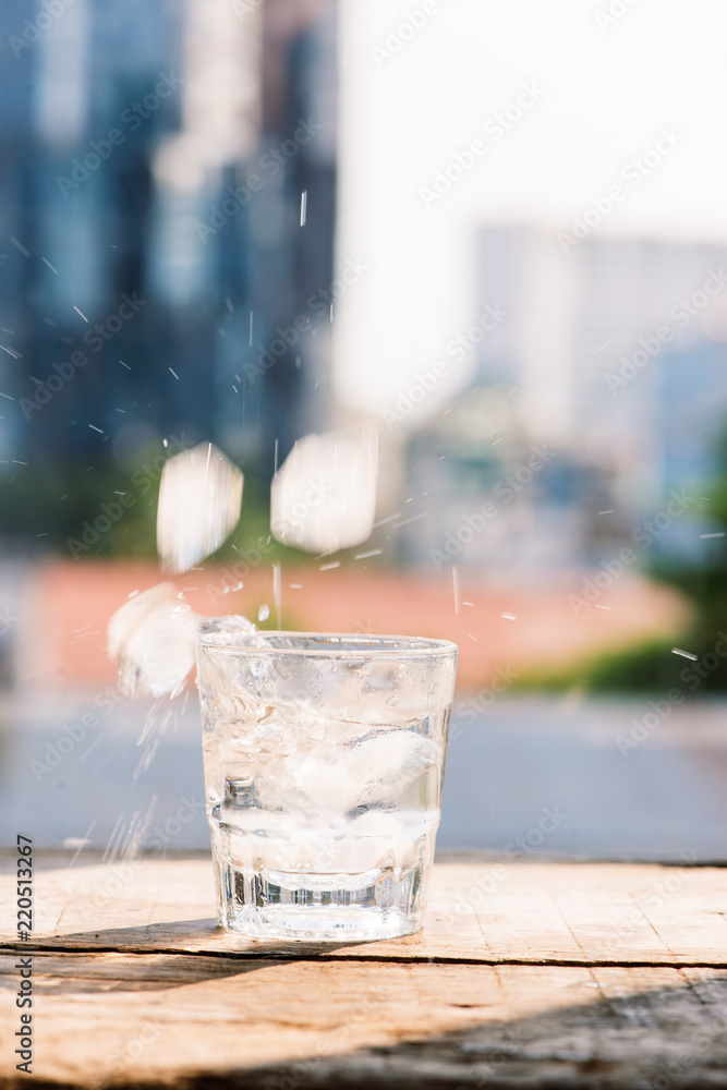 木桌上有冰块的玻璃杯