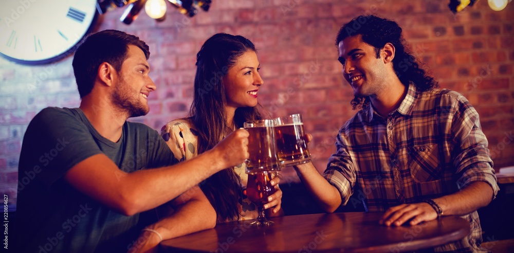 Young friends toasting beer mugs 