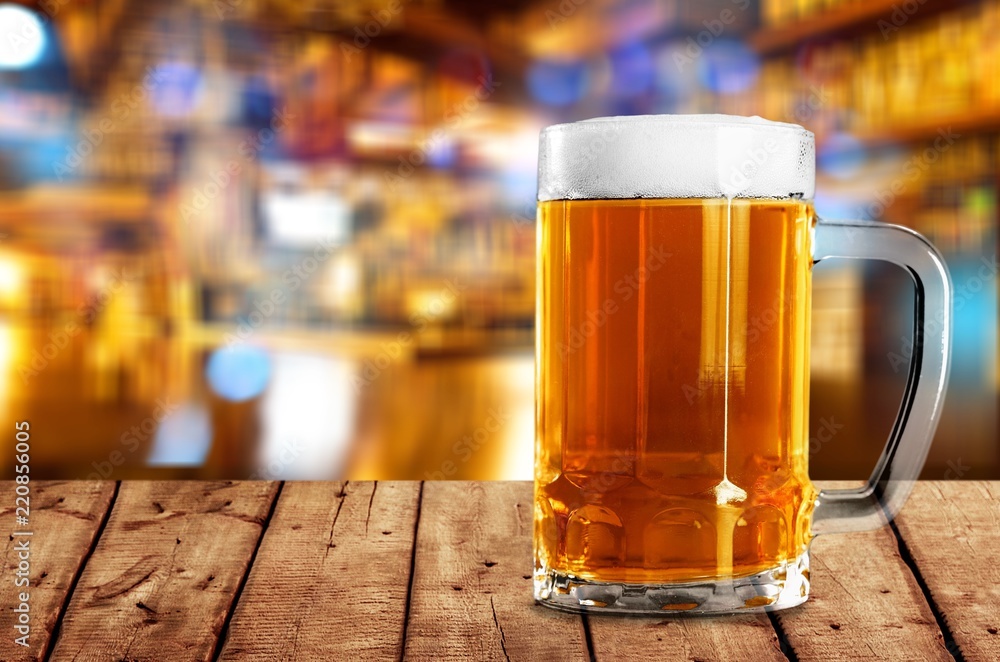 Mug of cold beer with foam, close-up view