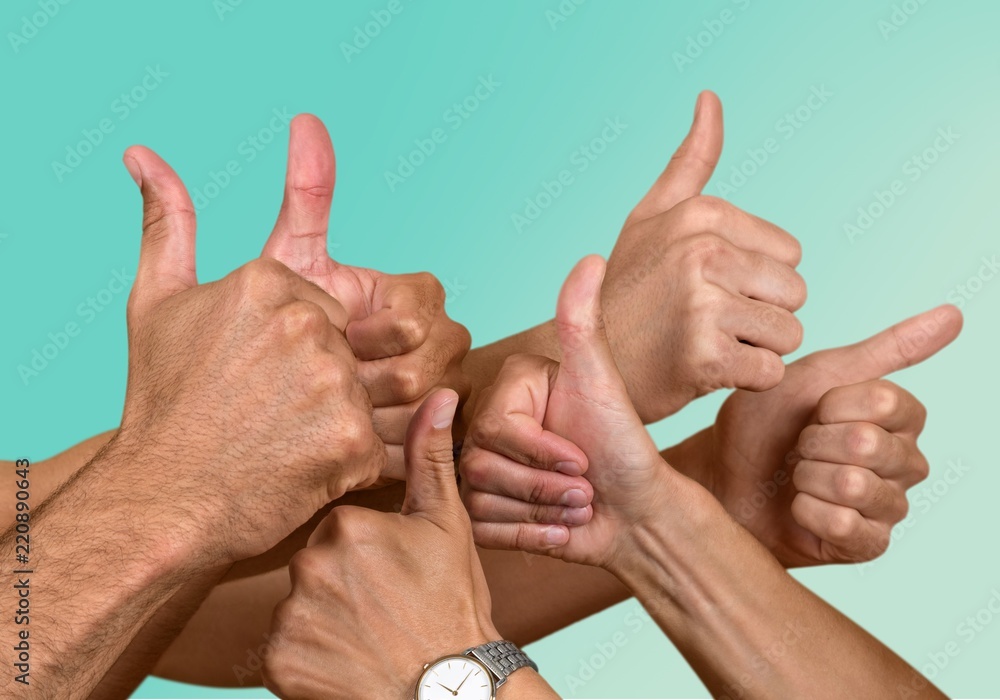 Closeup of male hand showing thumbs up sign against  background