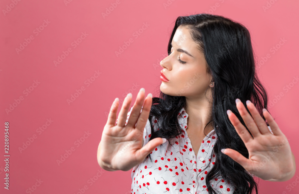 Young woman making a rejection pose on a solid background