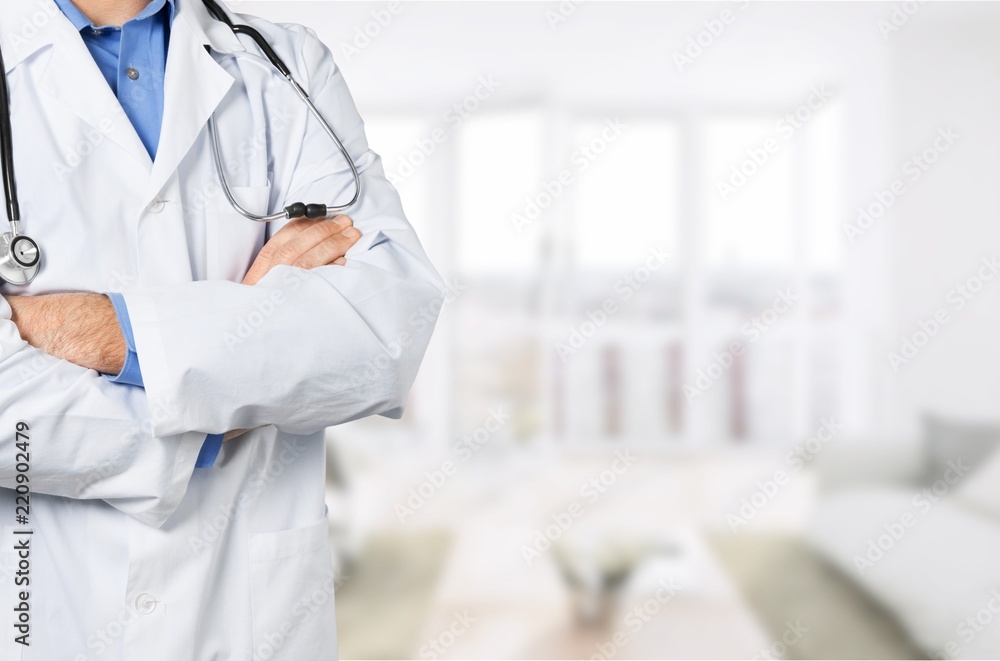 Male doctor with stethoscope on blurred hospital background