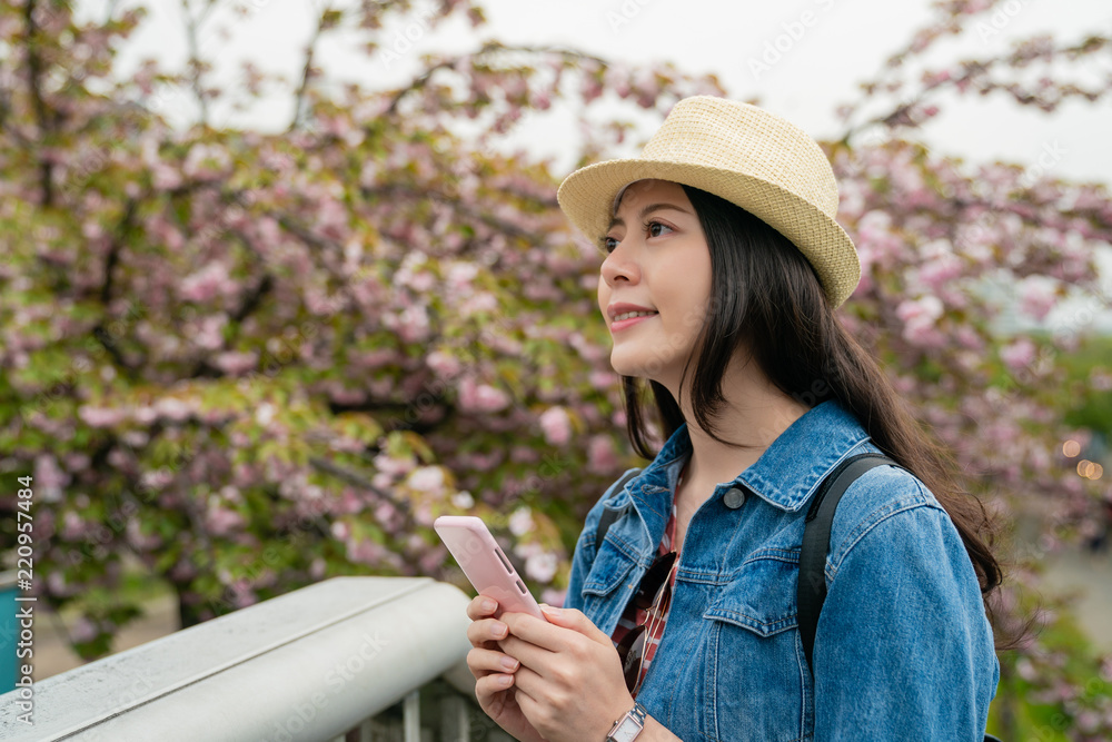 asian female using mobile and looking enjoyable.