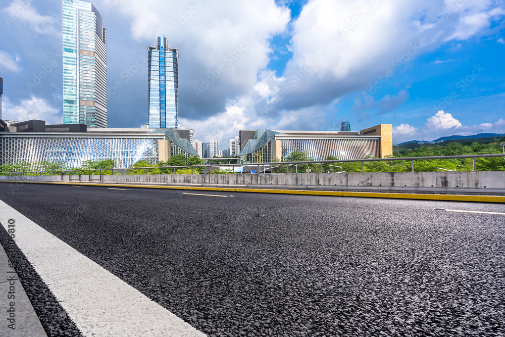 empty asphalt road with city skyline