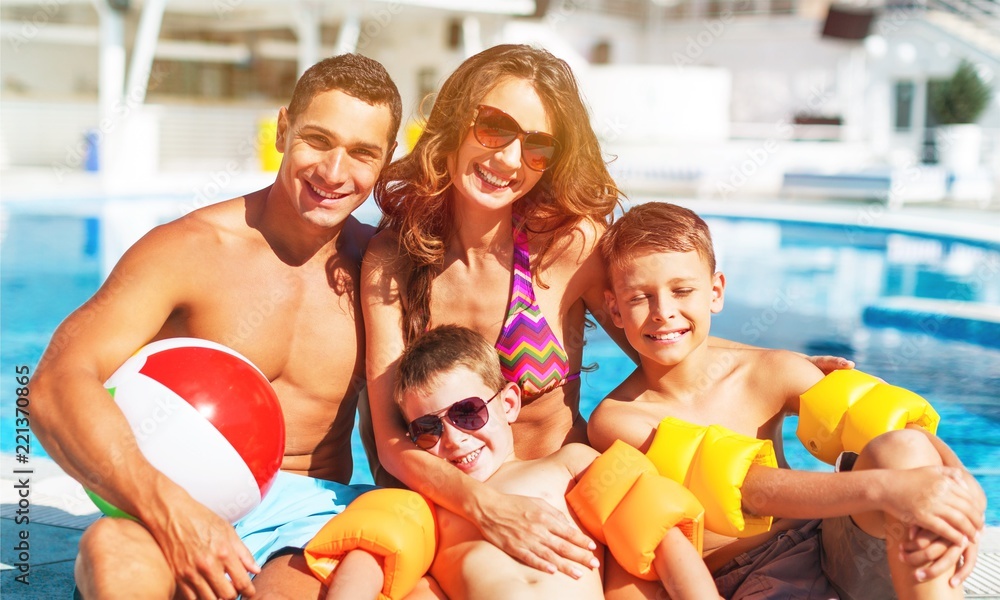 Happy family playing in swimming pool. Summer vacation concept