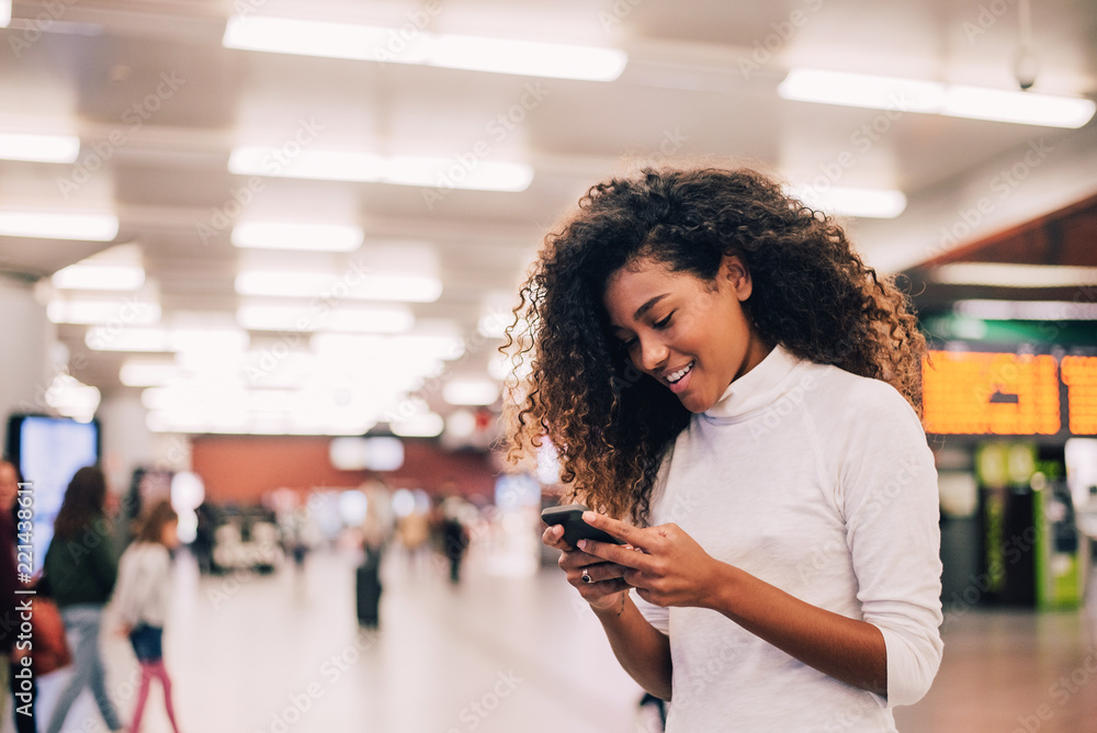 Gorgeous girl with curly hair using phone. Close-up.