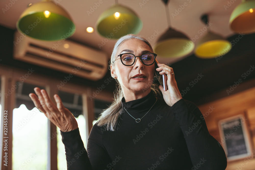 成熟女人在咖啡馆用手机聊天