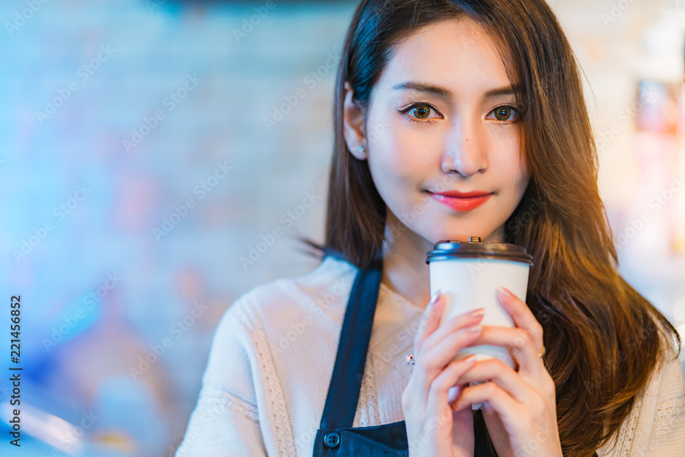 美丽迷人的亚洲咖啡馆店主带着咖啡杯围裙咖啡馆开心微笑