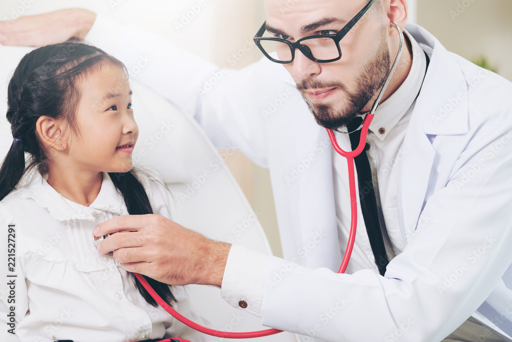 Doctor examining little happy kid in hospital.