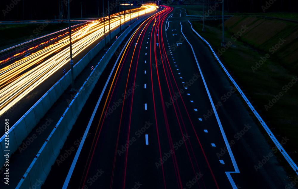 汽车夜间在弯曲的高速公路上照亮道路。夜间交通道路。运动模糊。夜间城市道路w