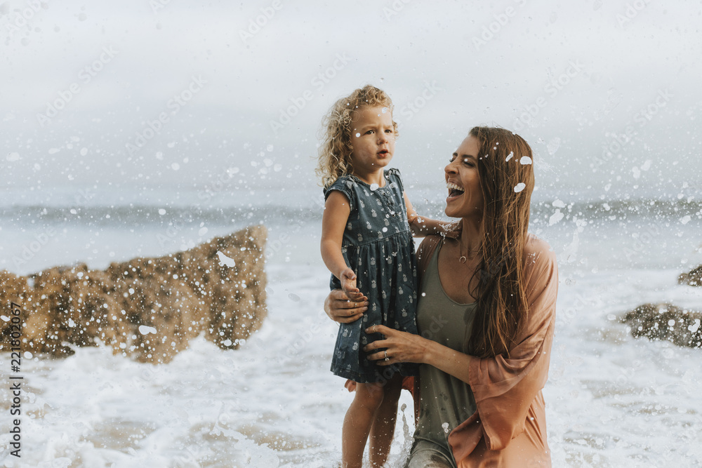 妈妈带着年幼的女儿在海滩上