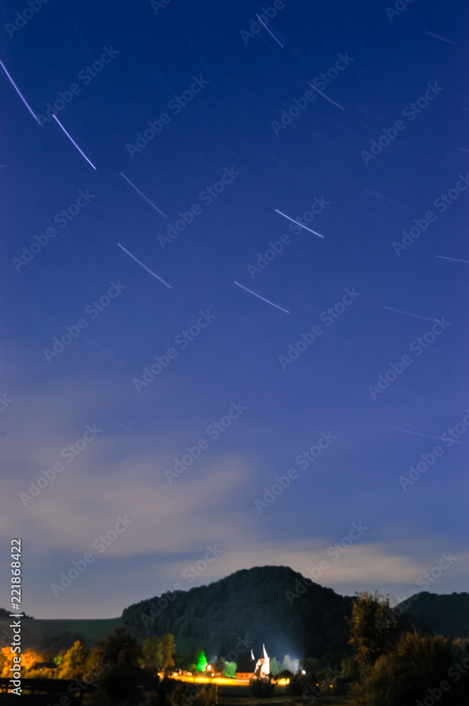 小村庄和天空的景观，夜晚有星星，长时间曝光