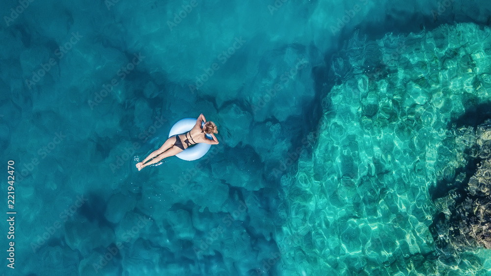 海上女孩的鸟瞰图。空气中的绿松石水作为背景。自然海景