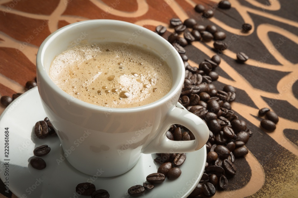 Cup of espresso and coffee beans on decorative table