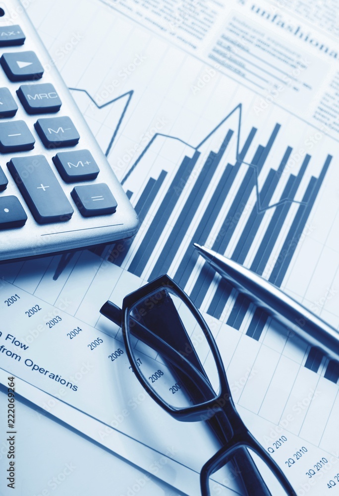 Calculator, Pen and Eyeglasses on Business Graphs