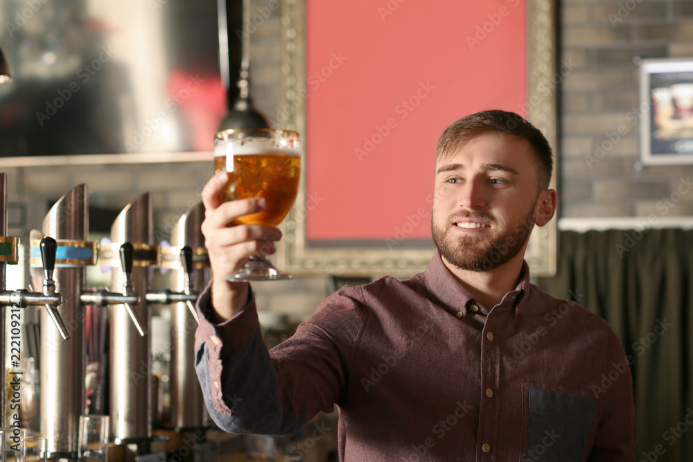 酒吧里有一杯啤酒的调酒师