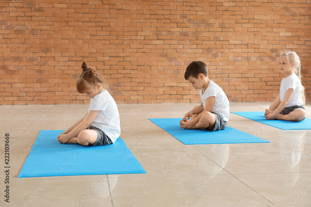 Little children practicing yoga indoors