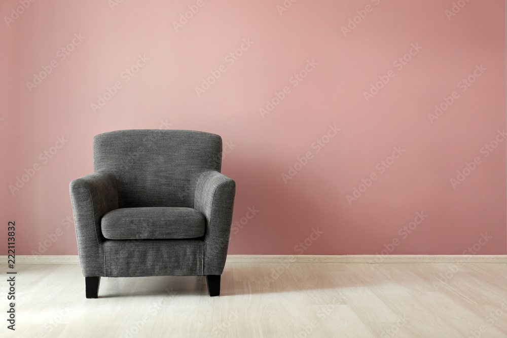 Comfortable armchair near color wall