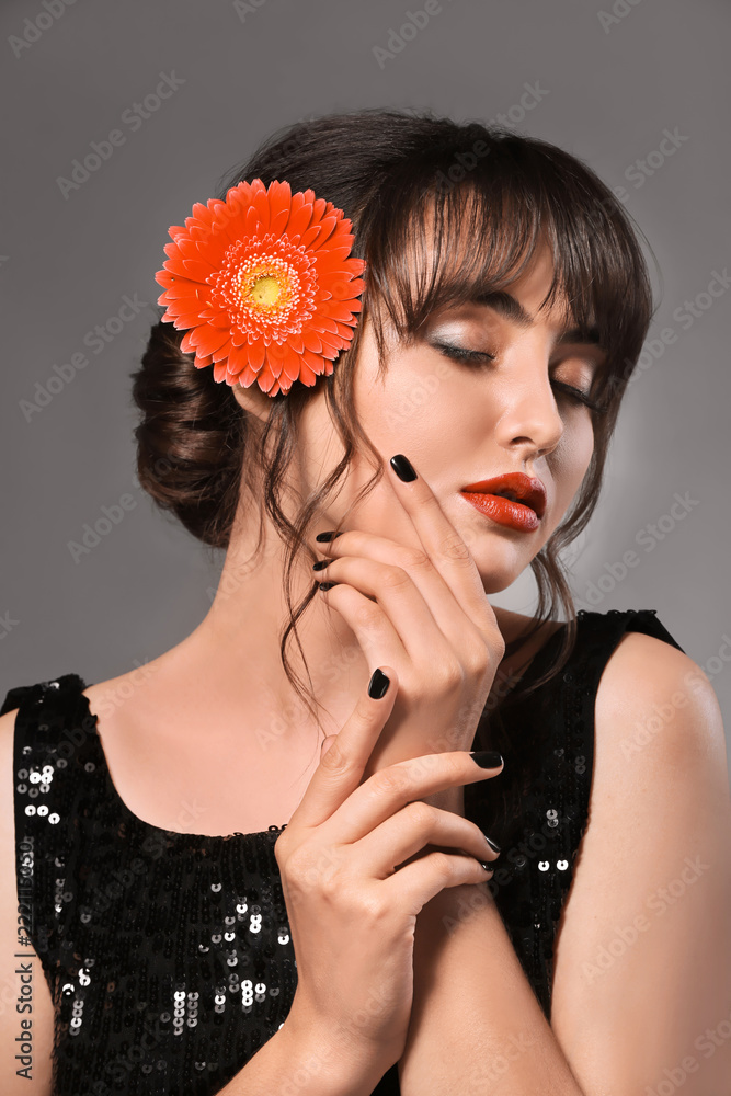 Beautiful young woman with professional manicure on grey background