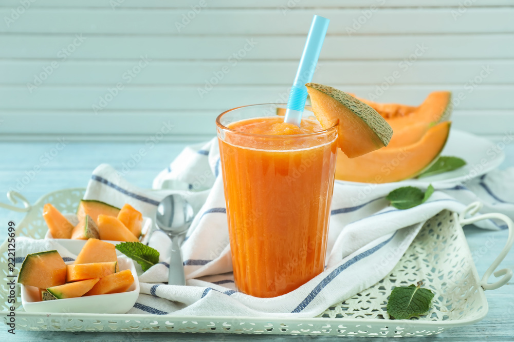 Glass of fresh melon smoothie on tray