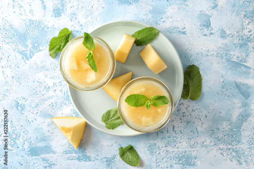 Glass jars with delicious melon smoothie on light table