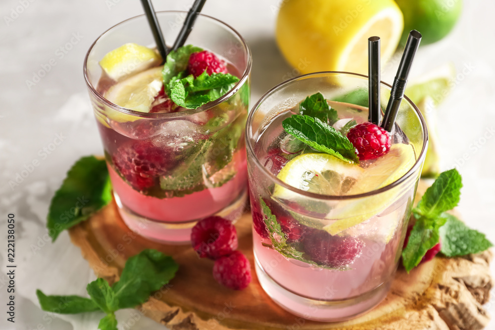 Glasses of fresh raspberry mojito on board