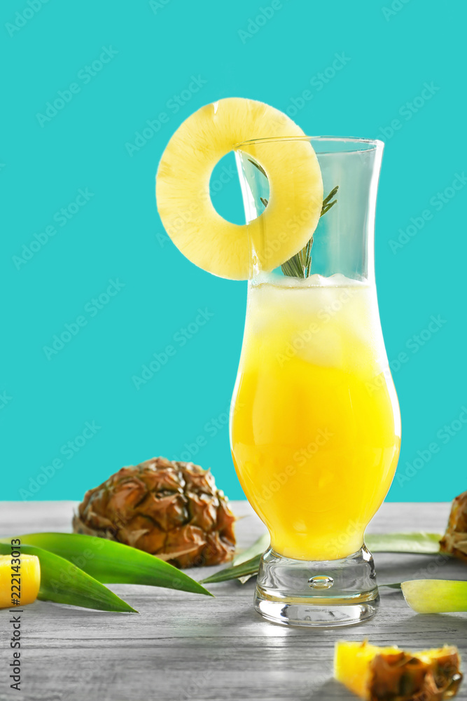 Glass of tasty fresh pineapple cocktail on light wooden table