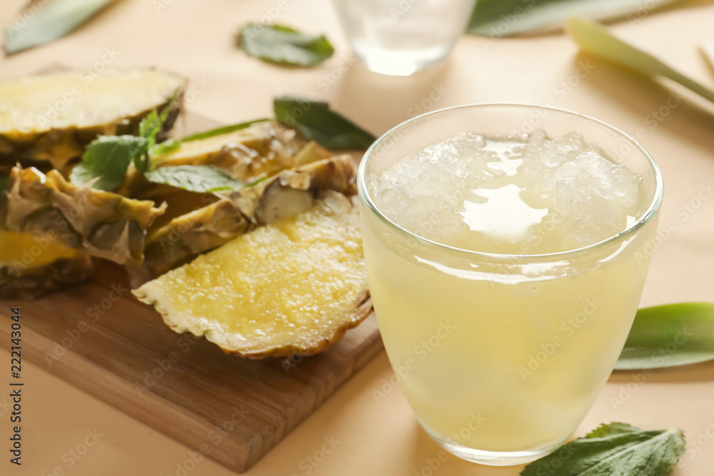 Glass with icy pineapple cocktail on light background