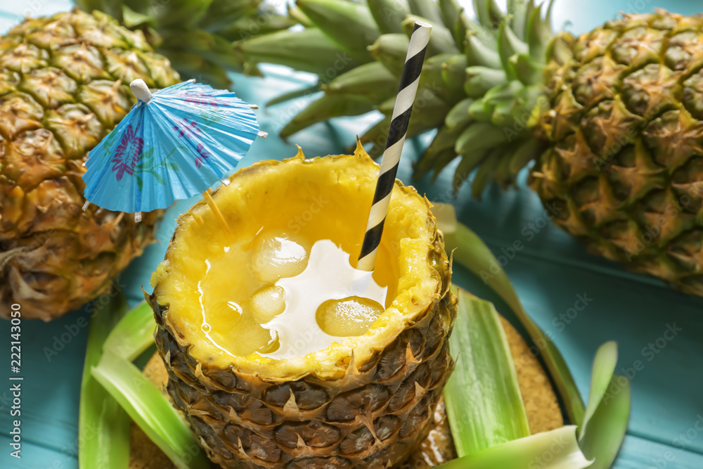 Cold delicious cocktail in pineapple on table