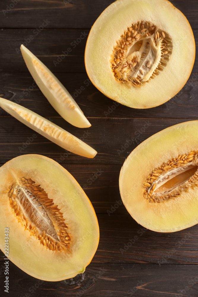 Cut sweet melon on dark wooden table