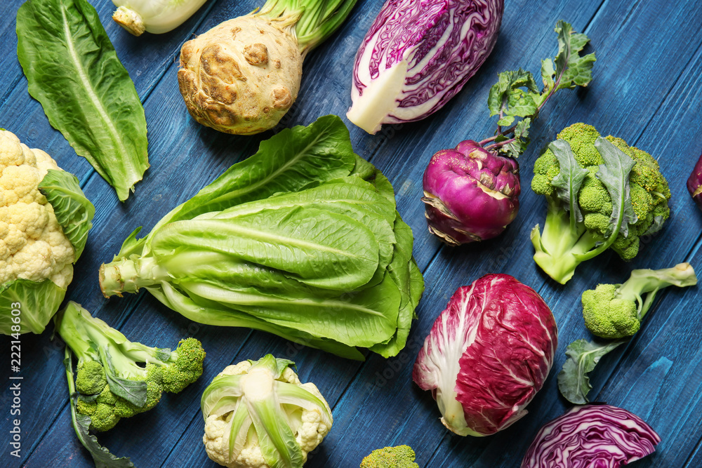 Different types of cabbage on color wooden background