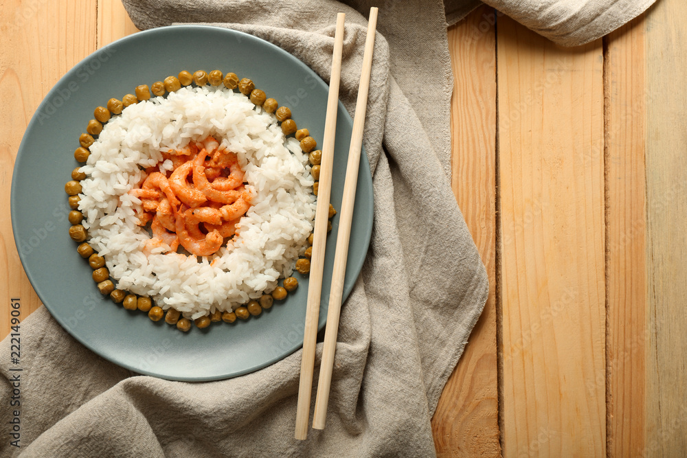 木桌上有煮好的米饭、豌豆和美味的虾