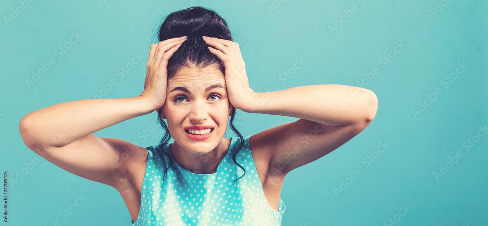 Young woman feeling stressed on a solid background