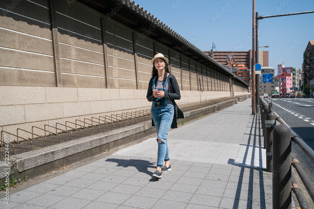 路过寺庙墙壁和街道的女人