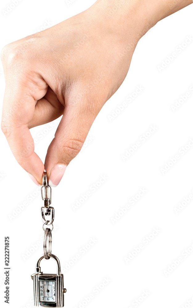 Female hand holding keychain with little clock and key isolated