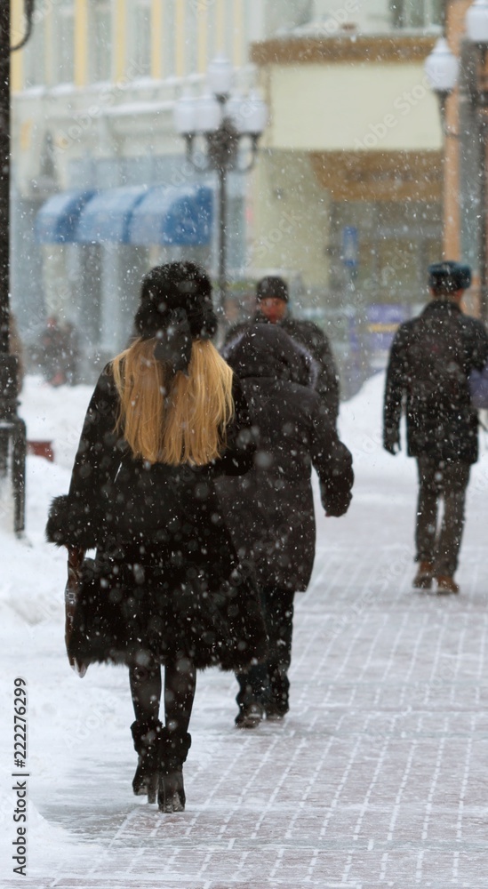 雪覆盖的城市街道，人们在散步