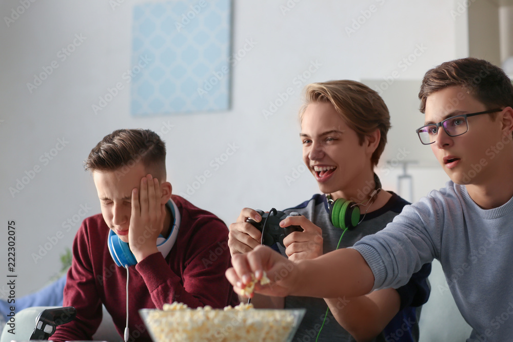 Teenagers playing video games at home